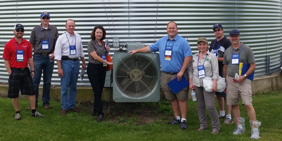 Agricultural professionals in front of grain bin